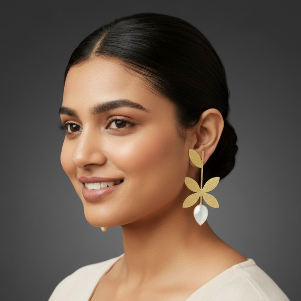 women wearing lumibella's Designer gold long leaf statement earrings.