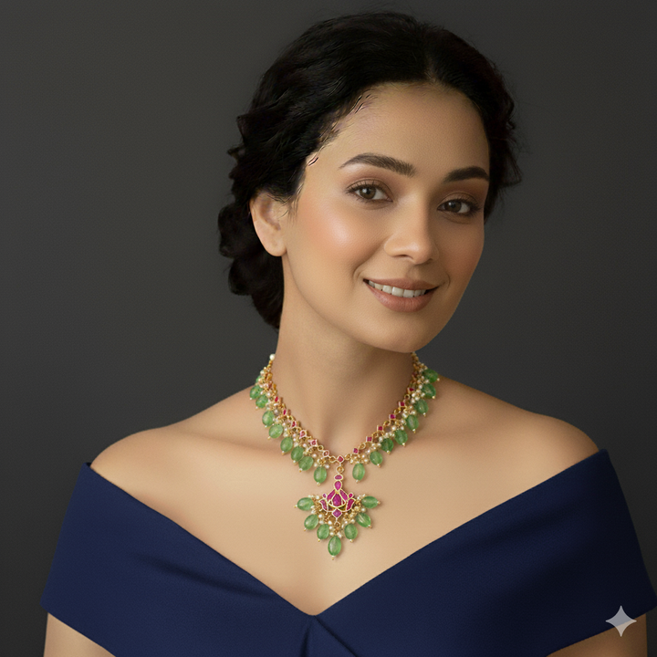 Woman wearing a green and gold jadau necklace.