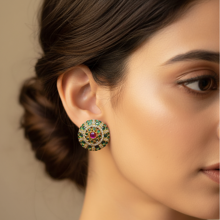 Model wearing green stud earrings. 