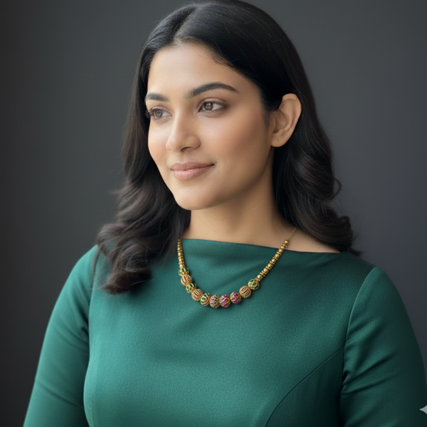 Woman wearing a green dress and beautiful golden bead necklace.