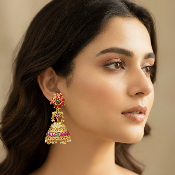 Woman wearing a coral gold jhumka earring.