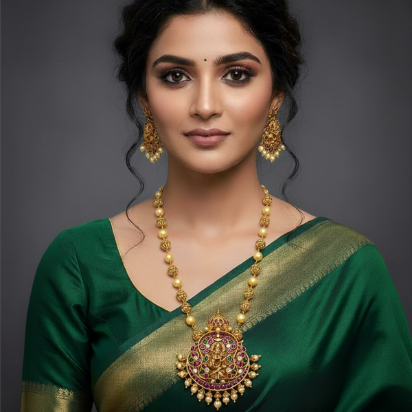 Woman wearing a green saree with gold pearl inspired jewelry  