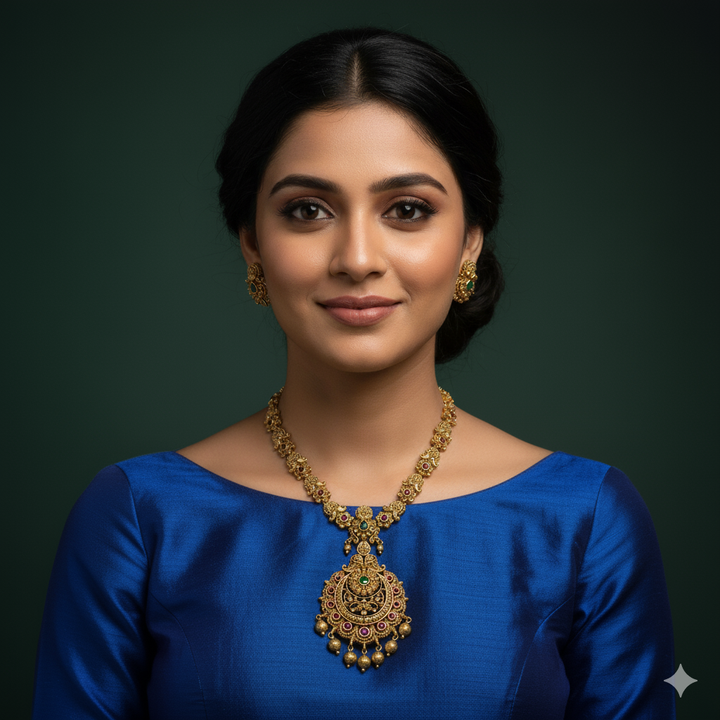 Woman wearing a blue top and matte gold jewelry 